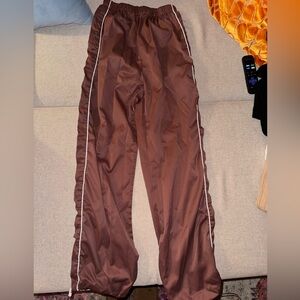 Brown joggers with white stripe down the side.